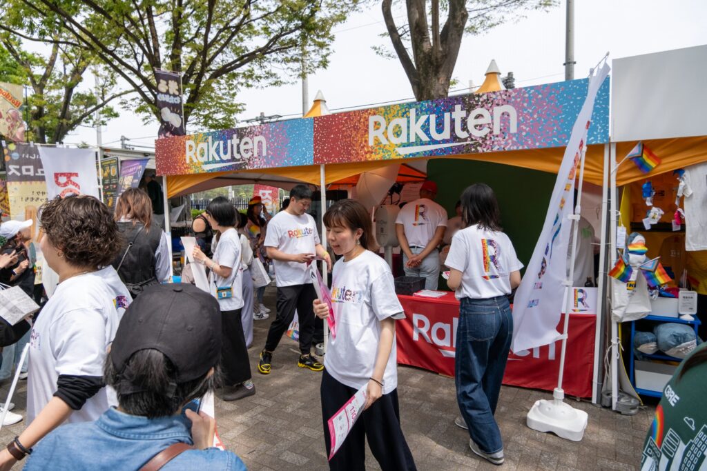 楽天グループが東京レインボープライド2024に出展したときのブースの画像。ブース前でスタッフがチラシ配布や、取り組みの紹介を行っている。